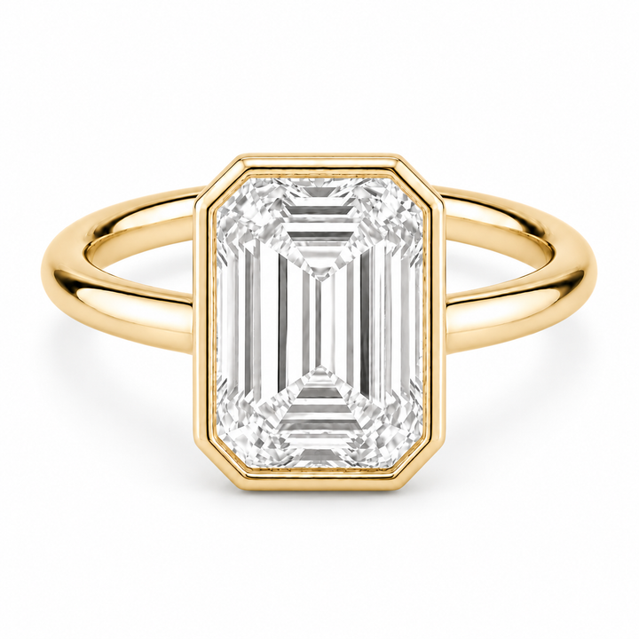 The Paragon emerald-cut lab diamond bezel ring in 14K yellow gold, front view on white