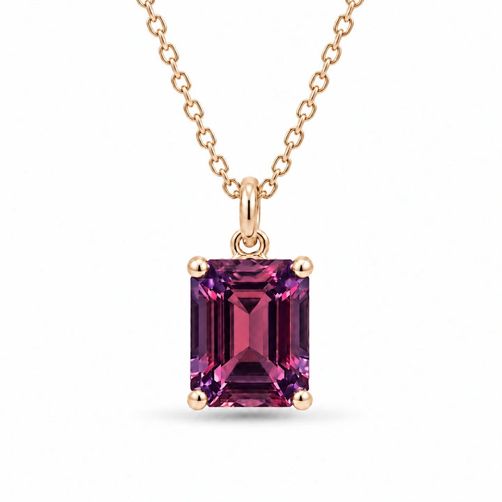 Emerald-Cut Lab Alexandrite Pendant in 14K Yellow Gold under warm indoor light, alexandrite color change