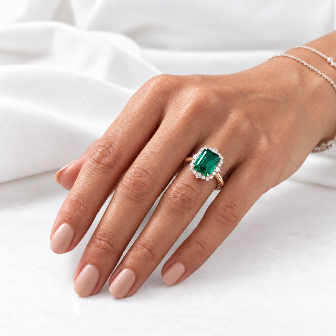 The Crown Halo — Diamond Halo Emerald Ring in 14K rose gold, on the hand