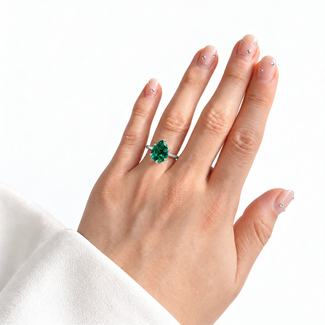The Lotus Lace — Pear Emerald Ring (Petal Setting) in 14K white gold, on the hand