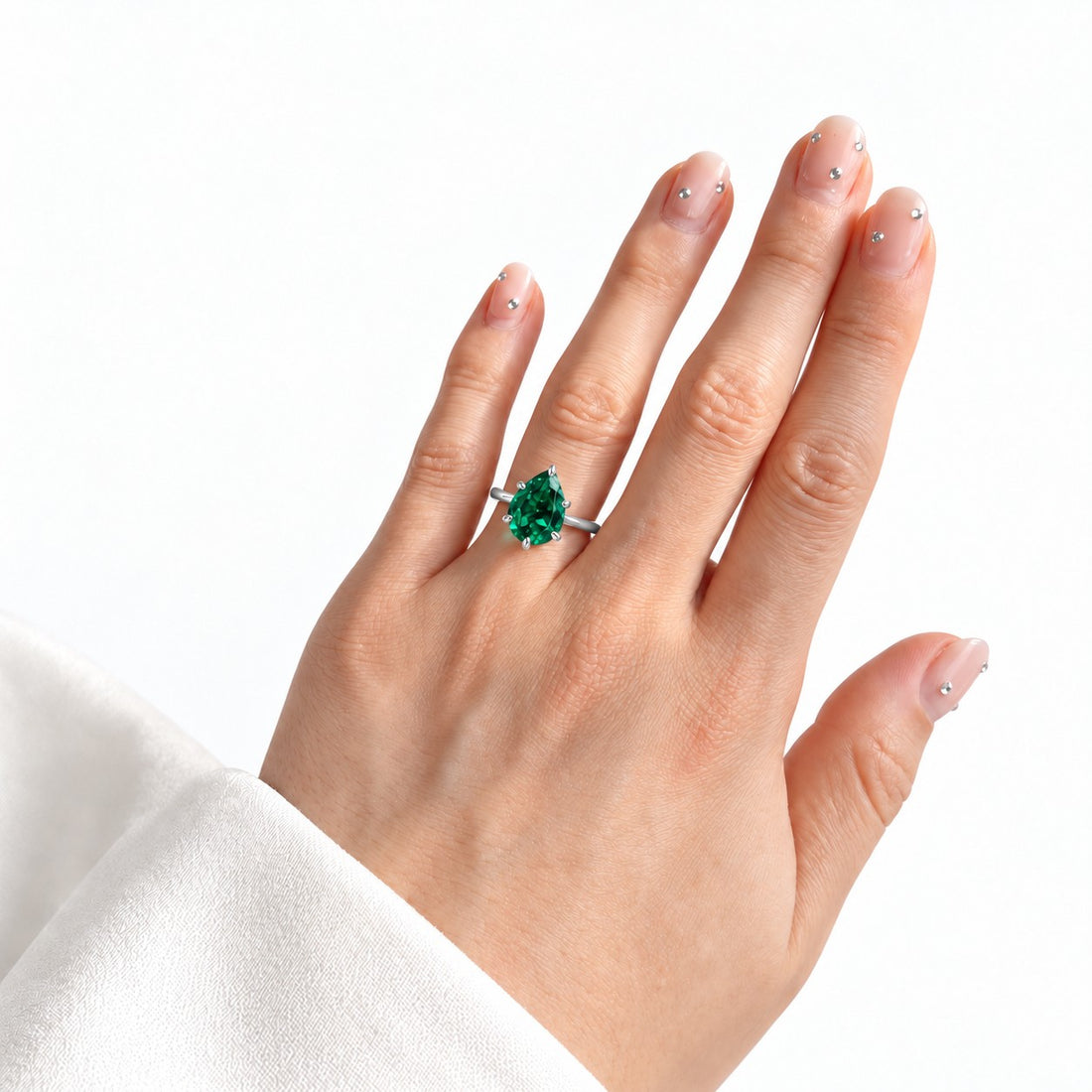 The Lotus Lace — Pear Emerald Ring (Petal Setting) in 14K white gold, on the hand