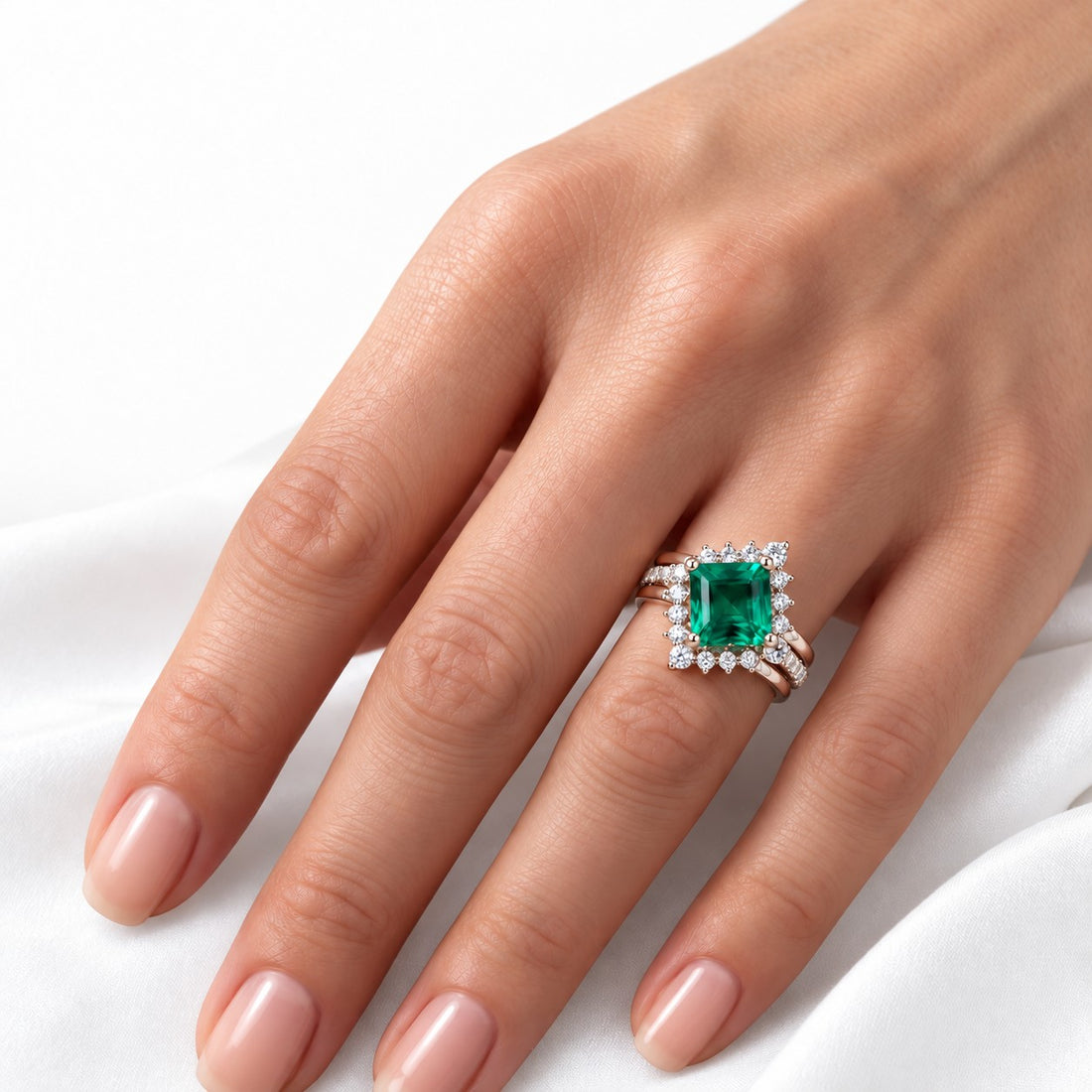 The Verdant Crown — Diamond Halo Emerald Ring (Twist Band) in 14K rose gold, on the hand
