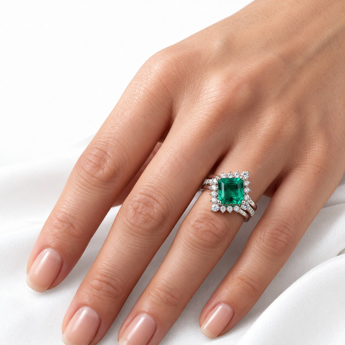 The Verdant Crown — Diamond Halo Emerald Ring (Twist Band) in 14K white gold, on the hand
