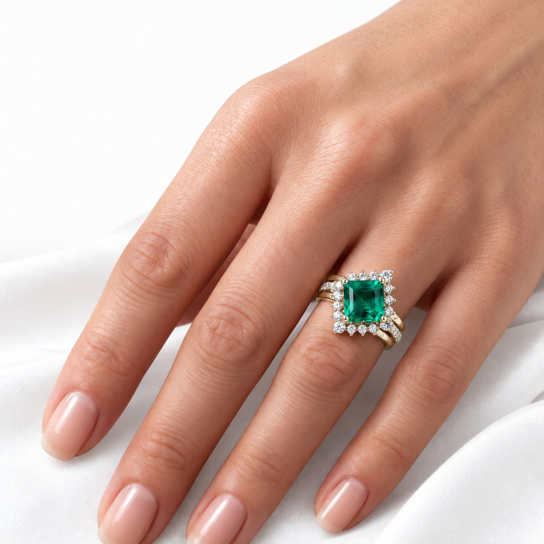 The Verdant Crown — Diamond Halo Emerald Ring (Twist Band) in 14K yellow gold, on the hand