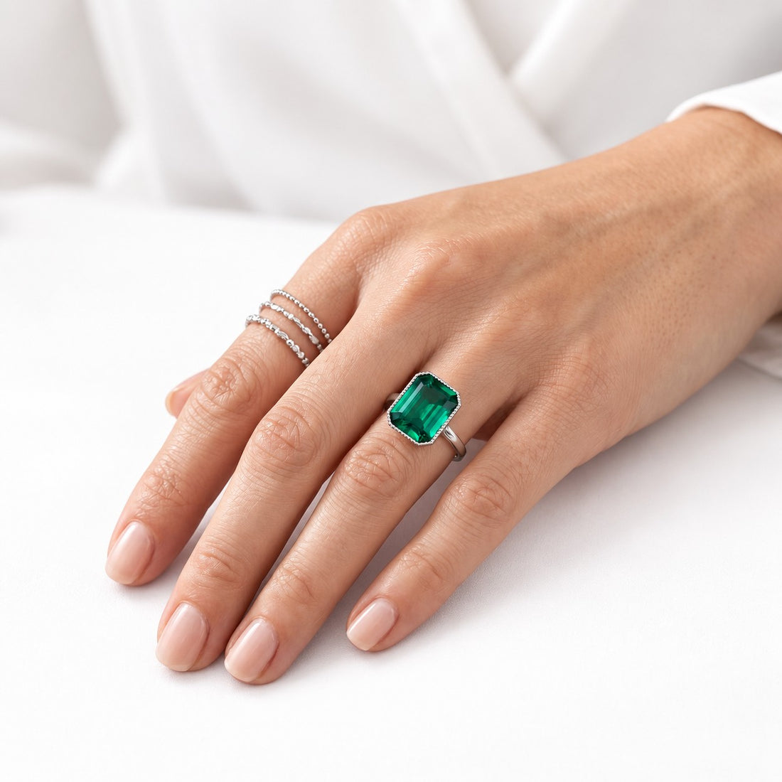 The Paragon — Milgrain Bezel Emerald Ring in 14K white gold, on the hand