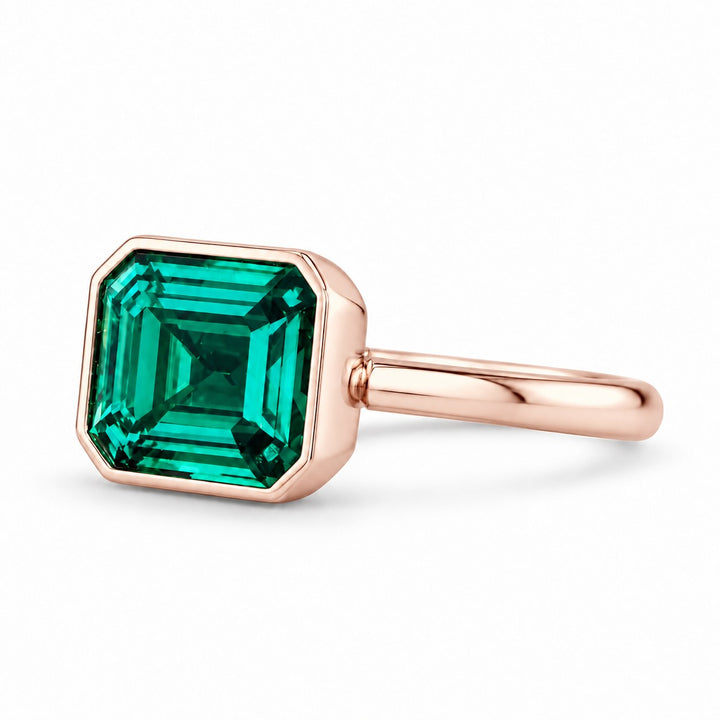 The Axis — East–West Emerald Ring in 14K rose gold, three-quarter view