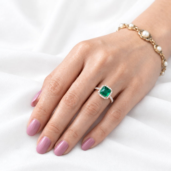The Prism — Diamond Halo Emerald Ring in 14K rose gold, on the hand