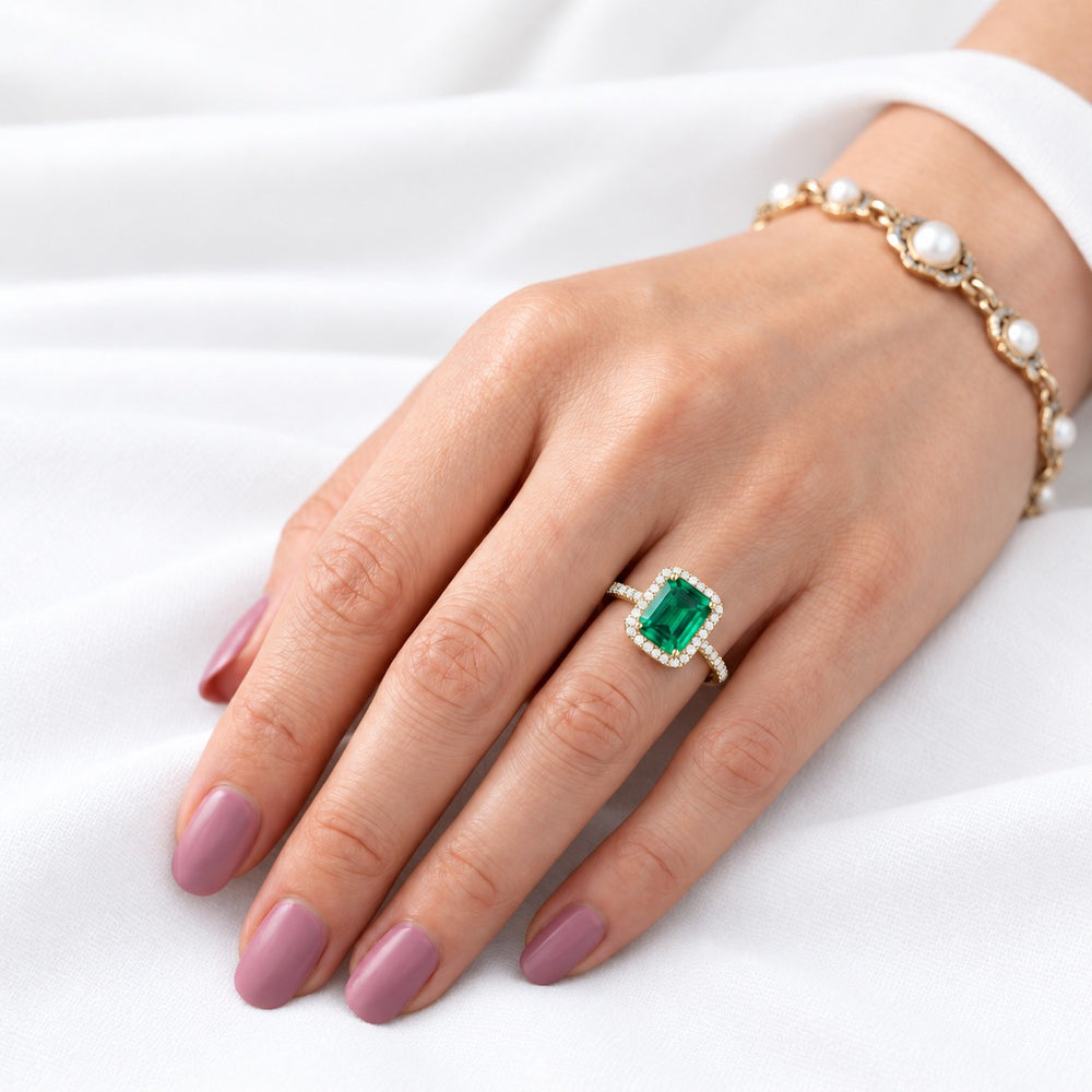 The Aurelia Halo — Diamond Halo/Band Emerald Ring in 14K yellow gold, on the hand