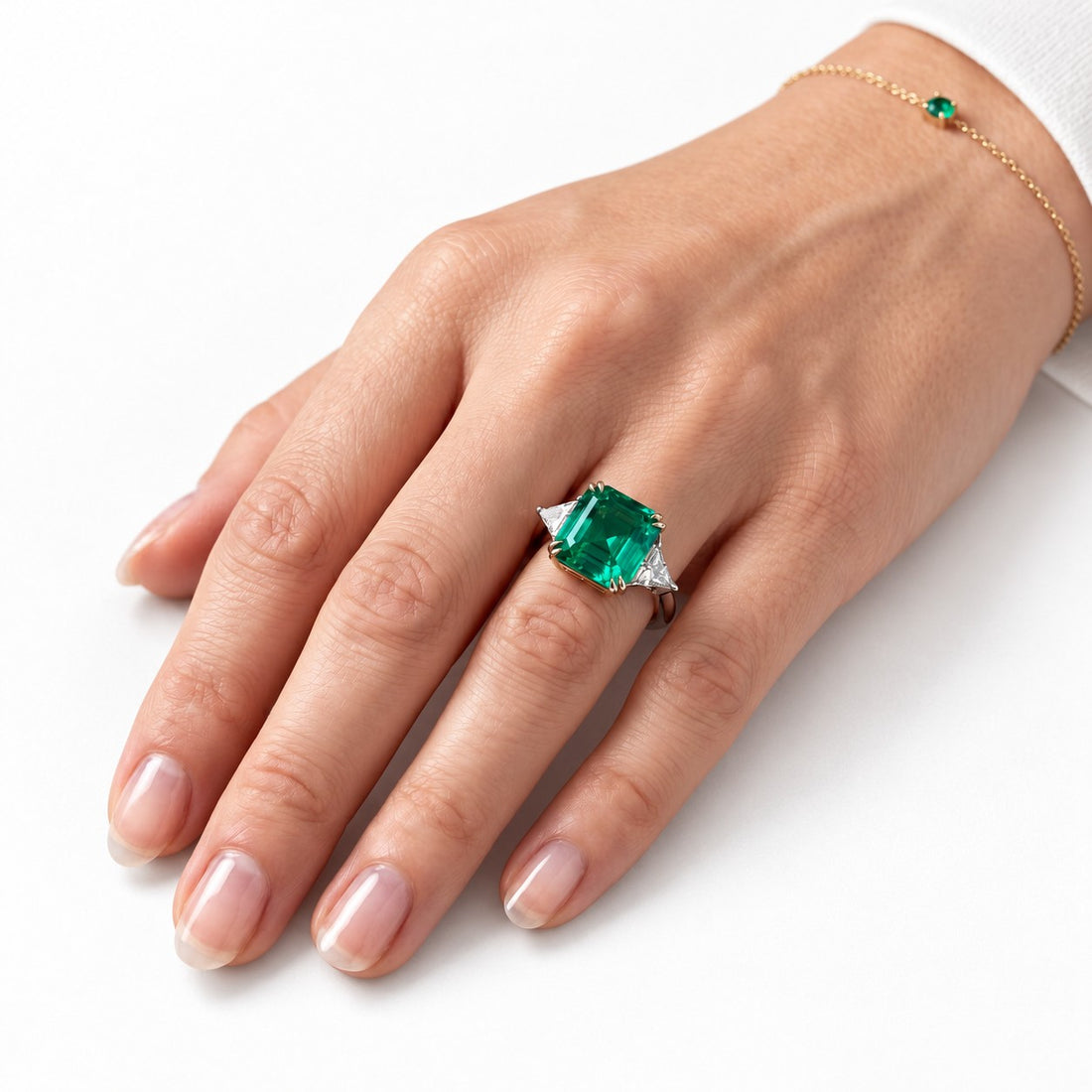 The Facet — Emerald Three-Stone Ring in 14K white gold, on the hand