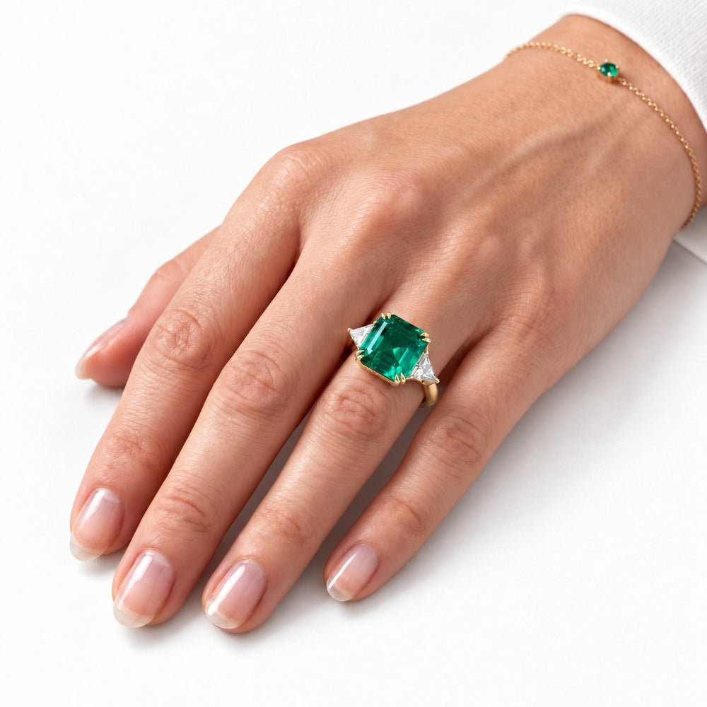 The Facet — Emerald Three-Stone Ring in 14K yellow gold, on the hand