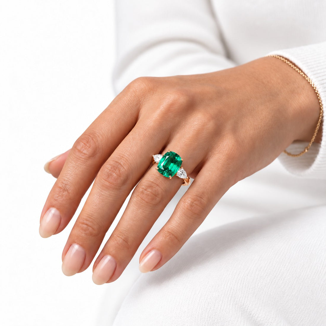 The Elysian — Cushion Three-Stone Emerald Ring in 14K rose gold, on the hand