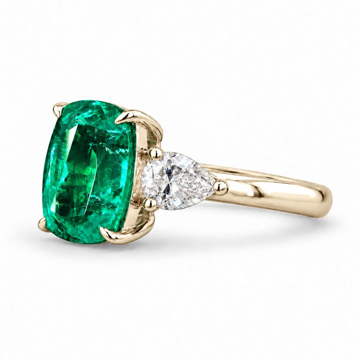 The Elysian — Cushion Three-Stone Emerald Ring in 14K yellow gold, three-quarter view