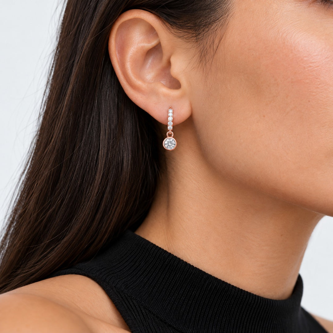 Bezel Drop Lab Diamond Huggie Earrings worn on the ear in 14K Rose Gold