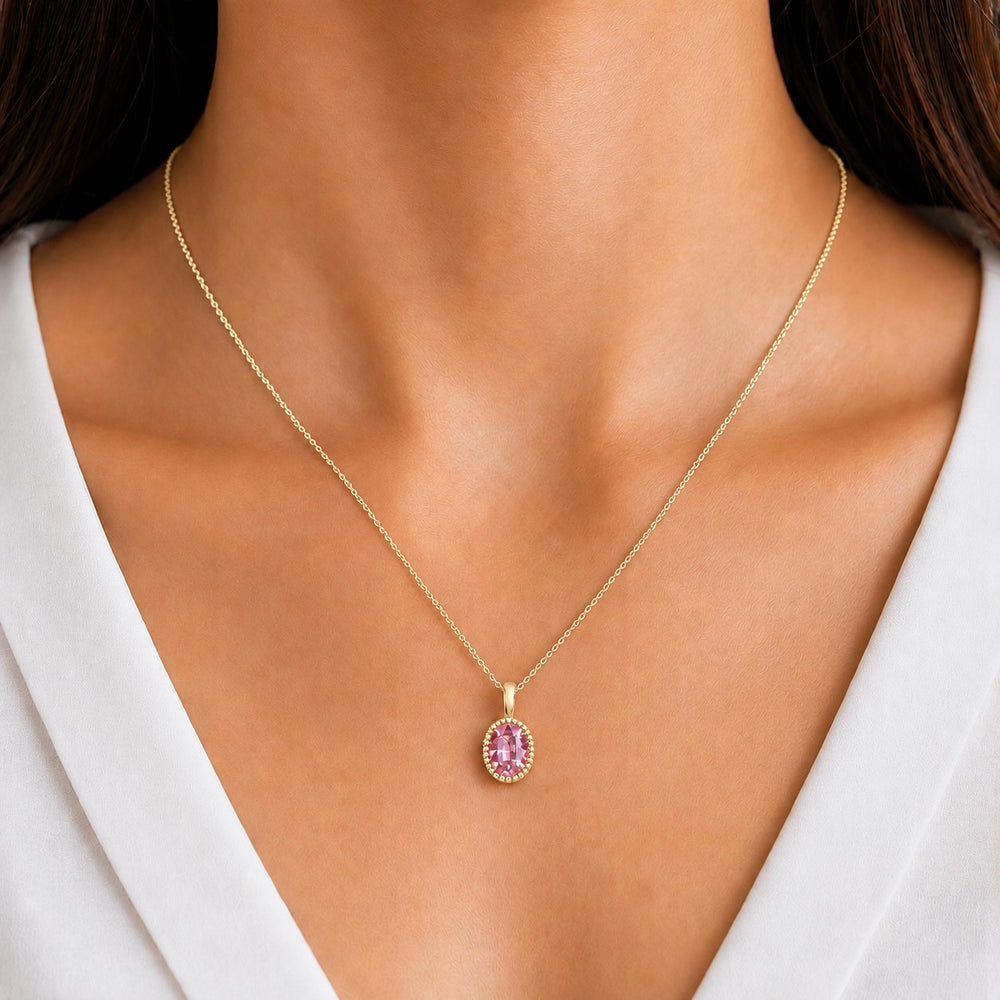 Oval Bezel Lab Pink Sapphire Pendant — 1.00ct worn on model in 14K Yellow Gold
