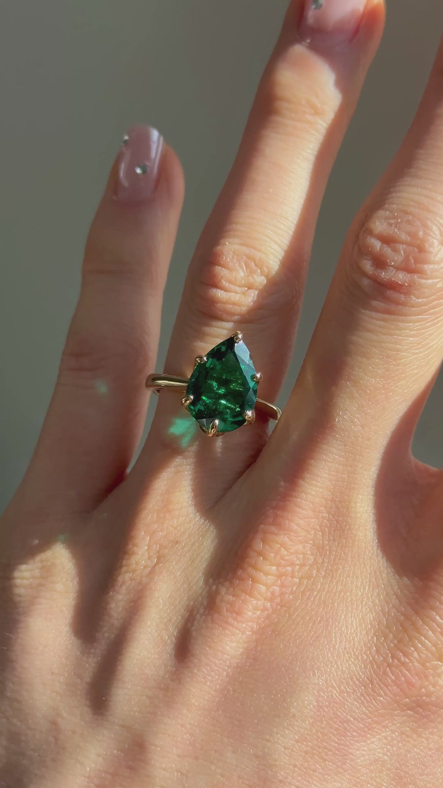 The Lotus Lace pear emerald in 14K yellow gold — worn on the hand (far to close) [ld m=y shot=wear]