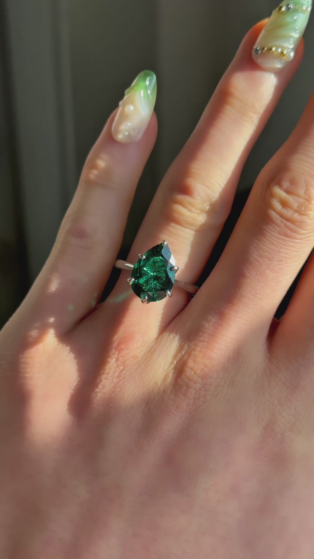The Lotus Lace pear emerald in 14K white gold / platinum — worn on the hand (far to close) [ld m=w shot=wear]