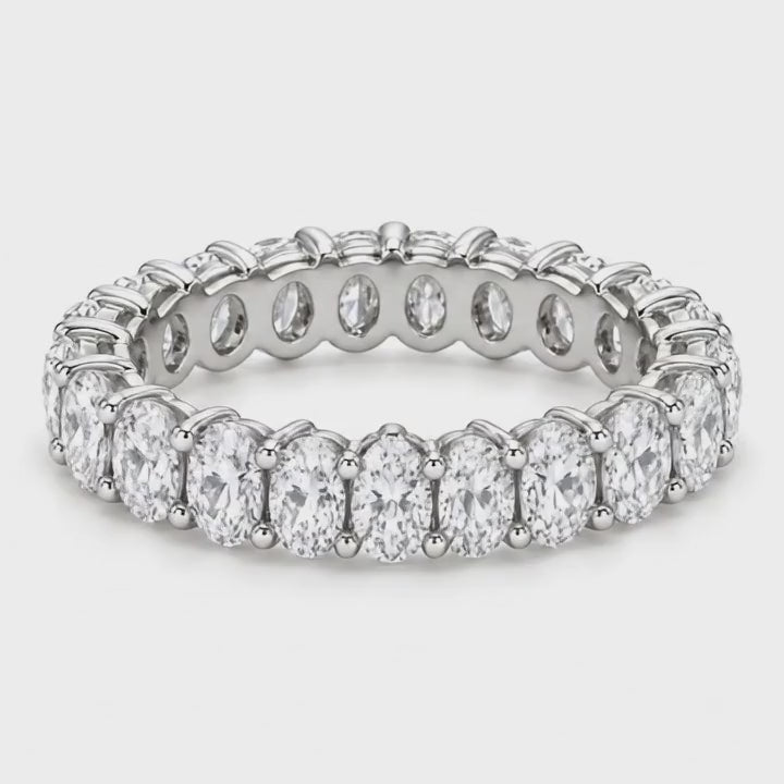 Oval lab-grown diamond eternity band in white gold turning on a white background
