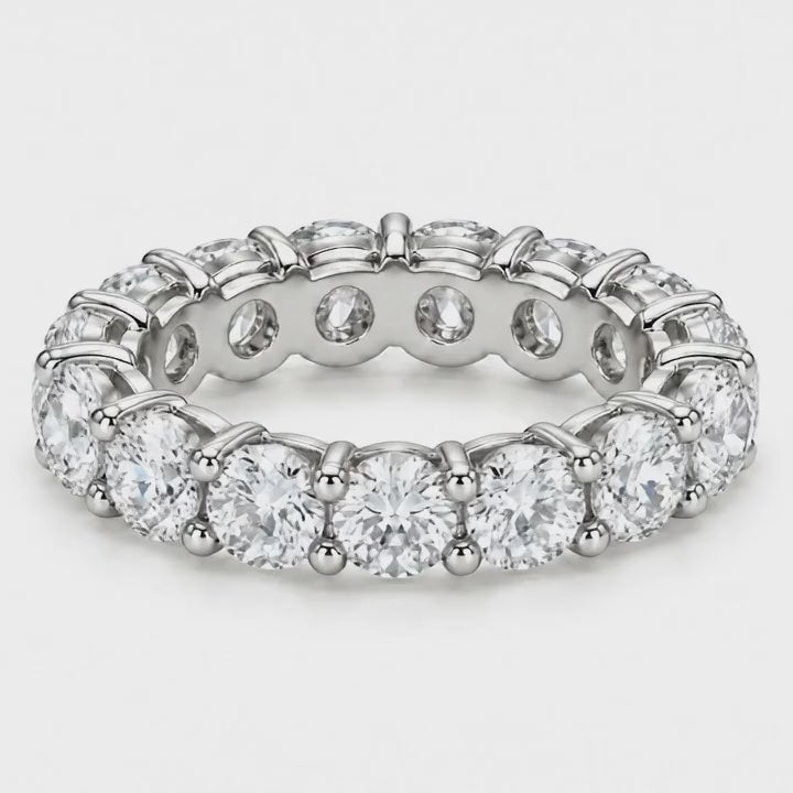 Classic round lab-grown diamond eternity band in white gold turning on a white background
