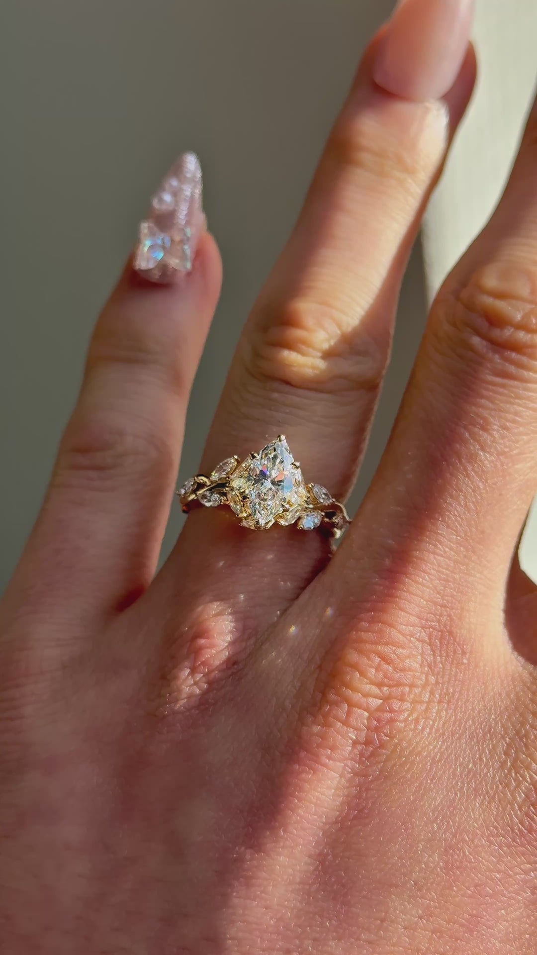 The Magnolia with a marquise center in 14K yellow gold — worn on the hand (far to close) [ld m=y shot=wear]