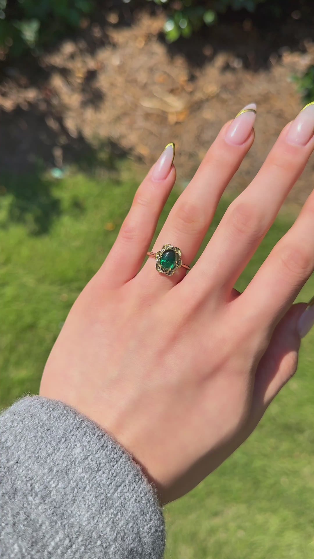The Bloom cabochon emerald in 14K yellow gold — worn on the hand (far to close) [ld m=y shot=wear]