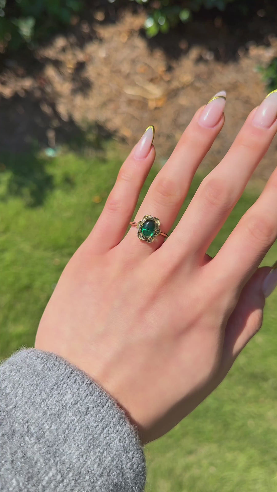 The Bloom cabochon emerald in 14K yellow gold — worn on the hand (far to close) [ld m=y shot=wear]