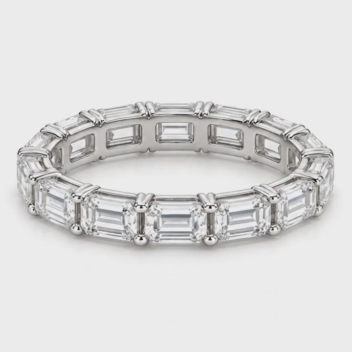 Emerald-cut lab-grown diamond eternity band in white gold turning on a white background