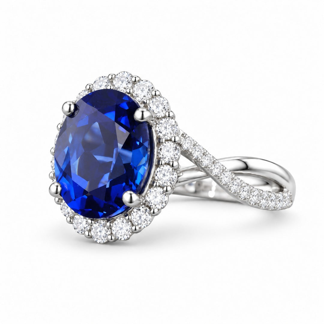 The Twisted Diana — Diamond Halo/Twist Band Oval Blue Sapphire Ring in 14K white gold, angled view