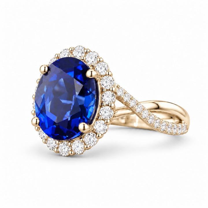 The Twisted Diana — Diamond Halo/Twist Band Oval Blue Sapphire Ring in 14K yellow gold, angled view