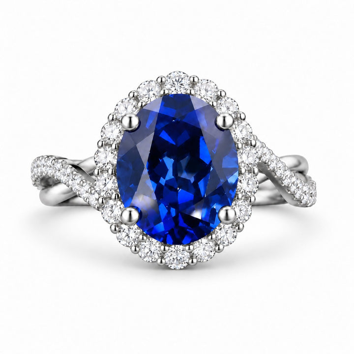 The Twisted Diana — Diamond Halo/Twist Band Oval Blue Sapphire Ring in platinum, front view