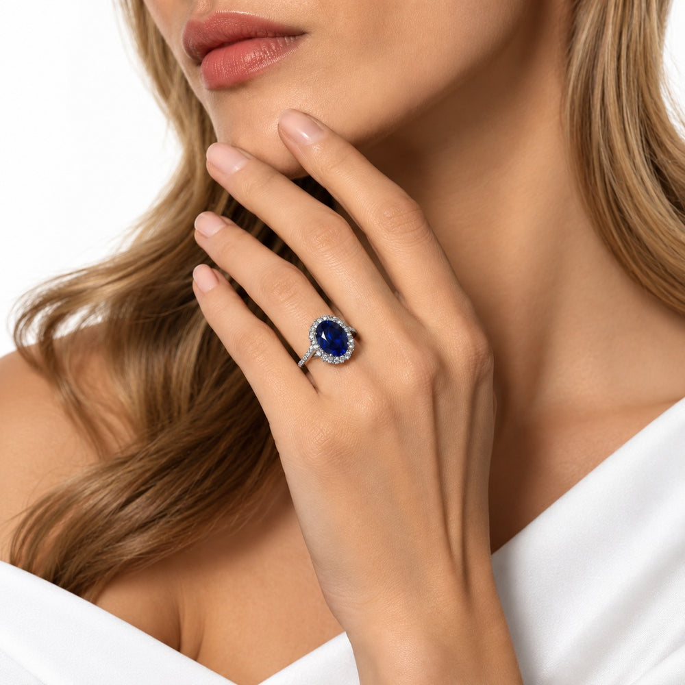 The Twisted Diana — Diamond Halo/Twist Band Oval Blue Sapphire Ring in 14K white gold, worn on hand