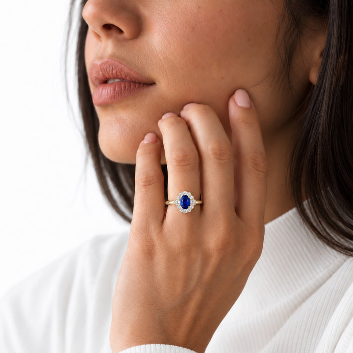 The Marielle — Petite Sapphire Halo Ring in 14K yellow gold, worn on hand