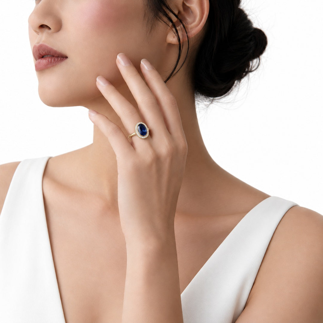 The Celine vintage lab sapphire halo ring in 14K yellow gold, worn on hand