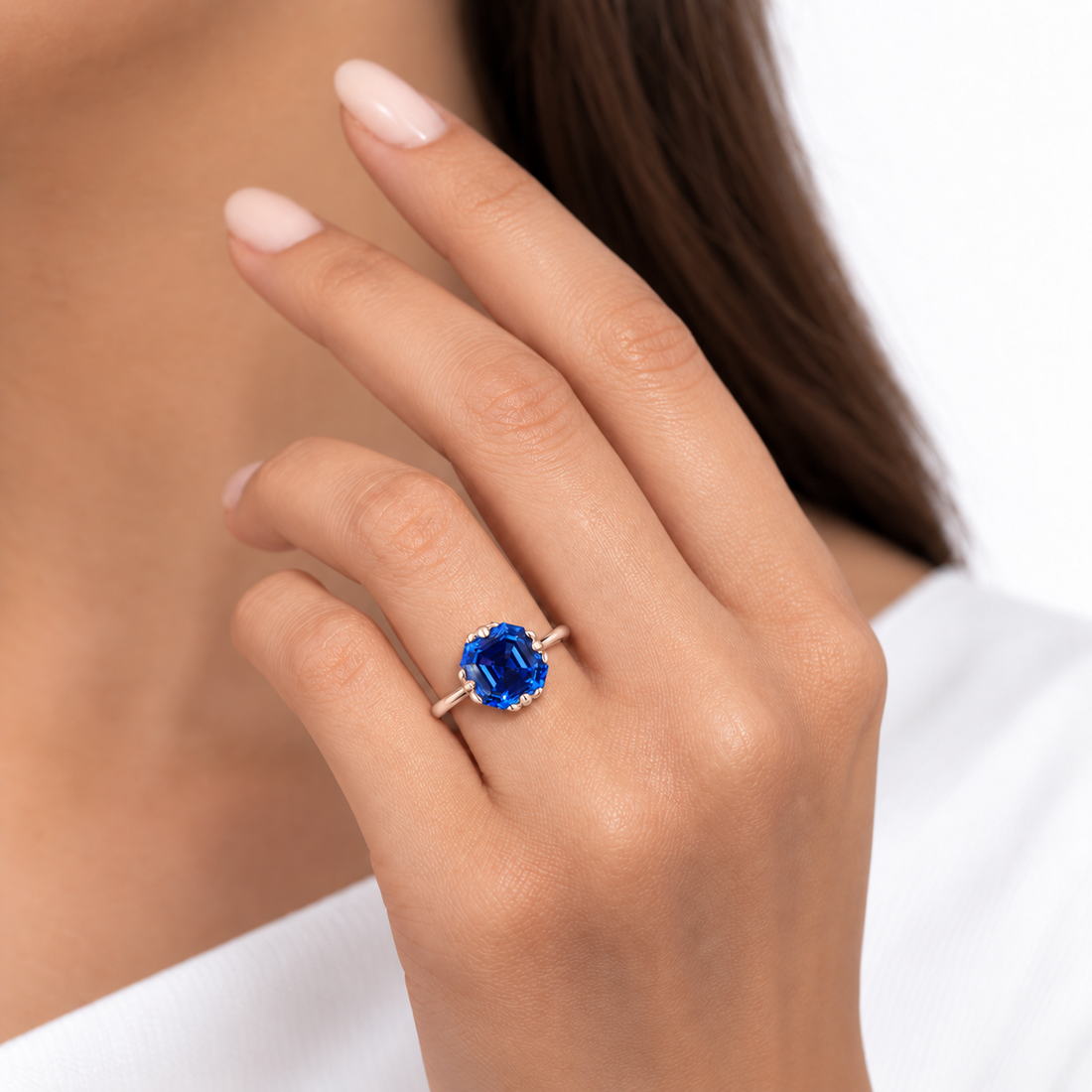 The Verena Asscher blue sapphire ring with leaf prongs in 14K rose gold, worn on hand