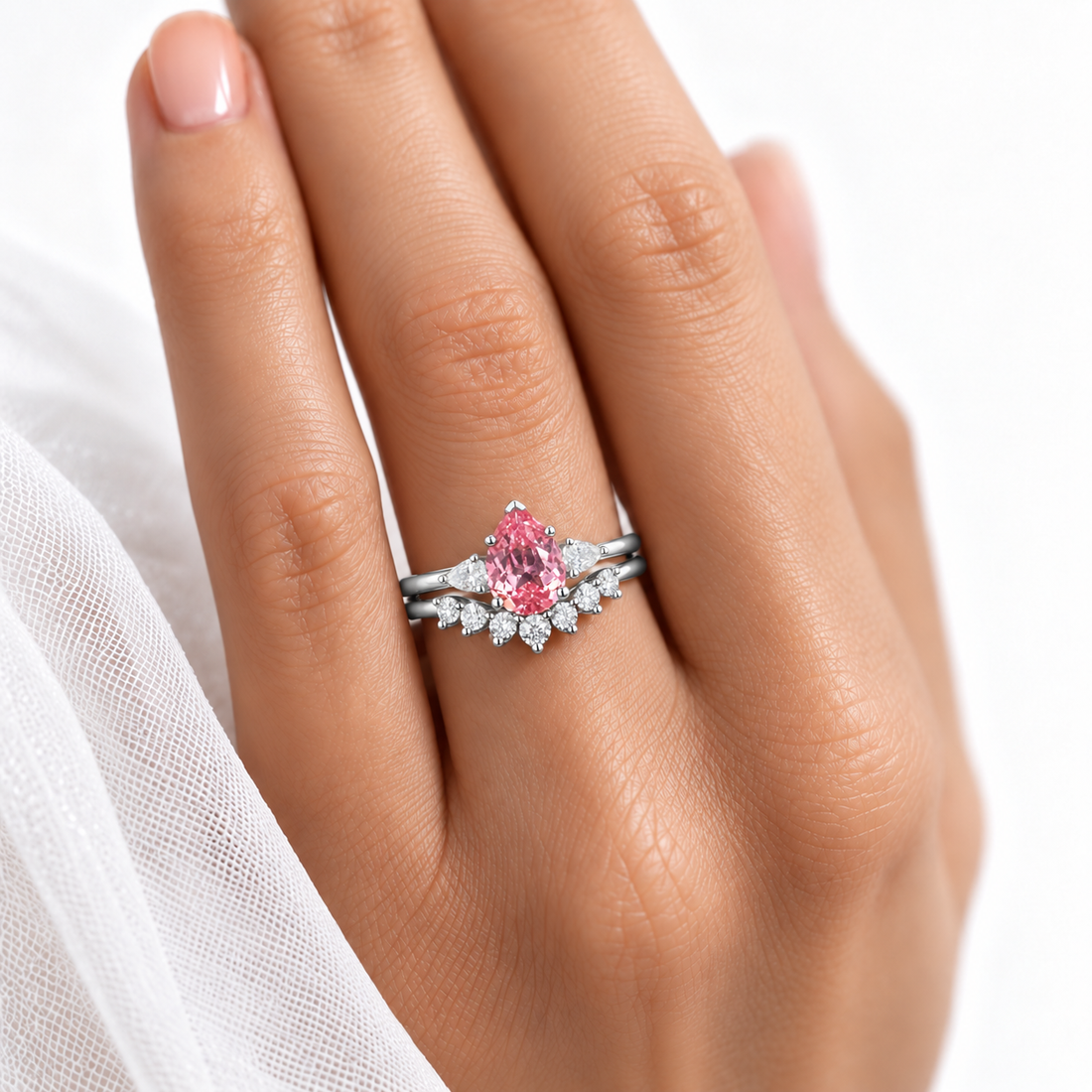 The Aubrey Set pink pear sapphire three-stone ring and diamond band in platinum, worn on hand