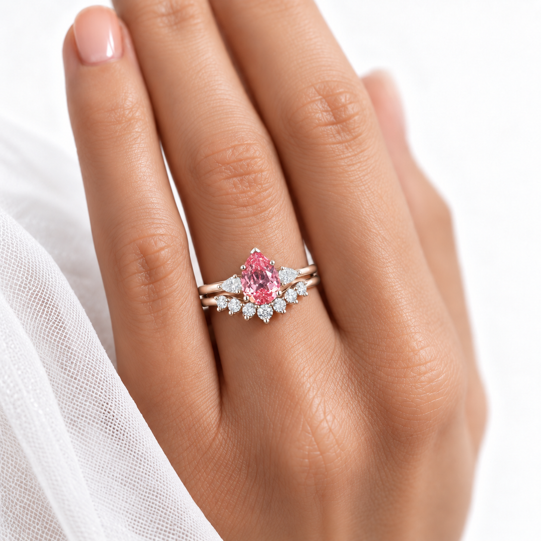 The Aubrey Set pink pear sapphire three-stone ring and diamond band in 14K rose gold, worn on hand