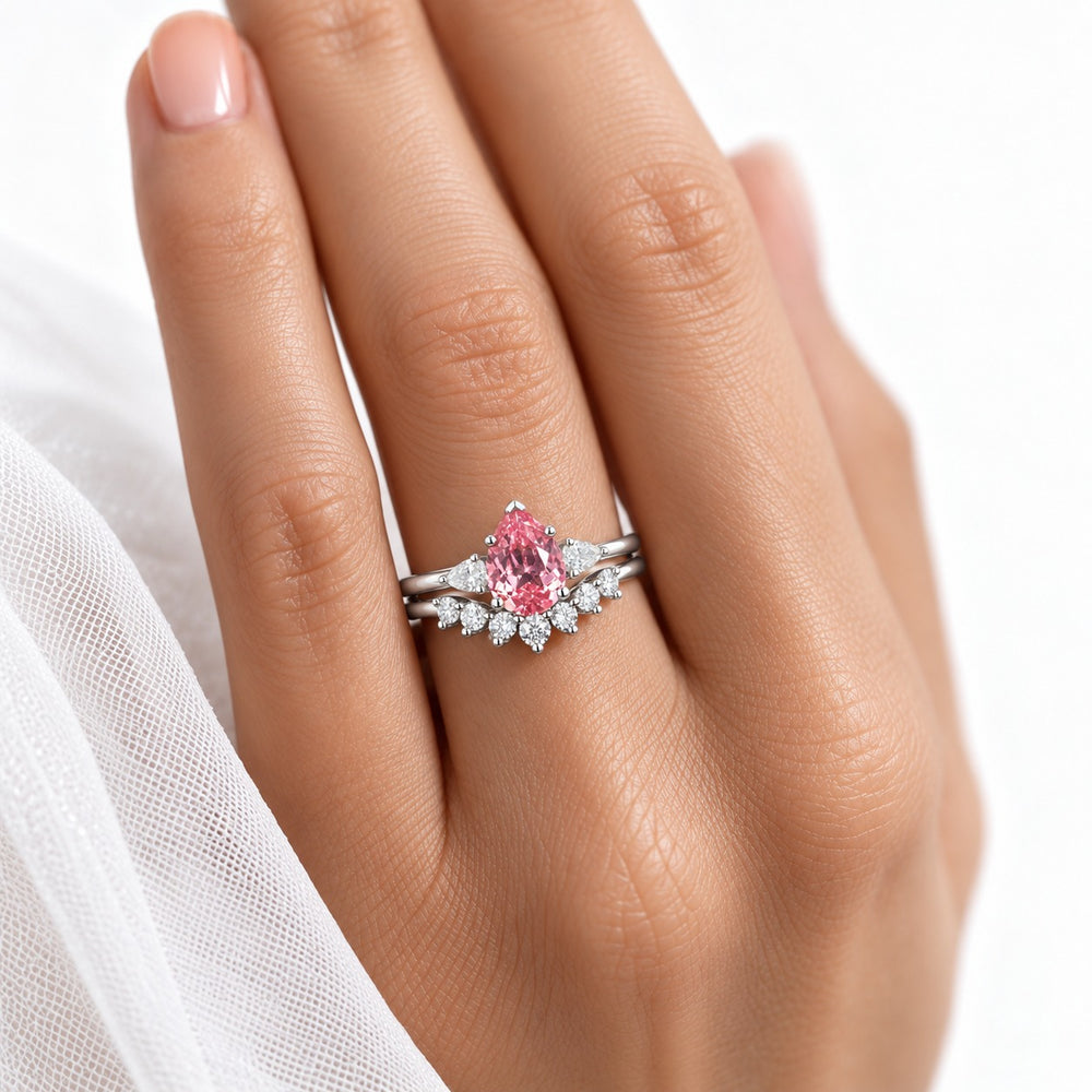 The Aubrey Set pink pear sapphire three-stone ring and diamond band in 14K white gold, worn on hand