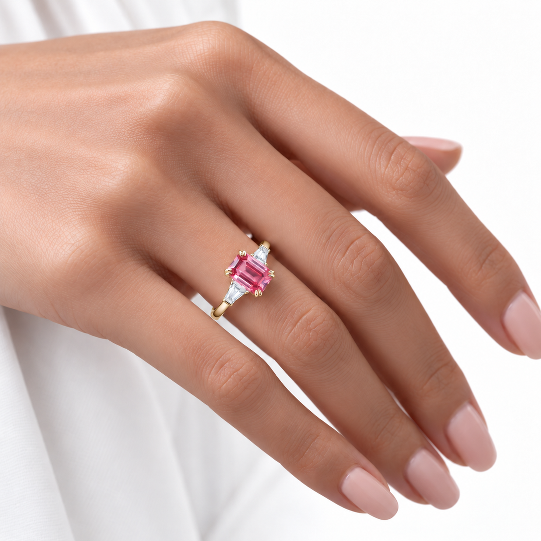 The Lumen pink lab sapphire baguette ring in 14K yellow gold, worn on hand