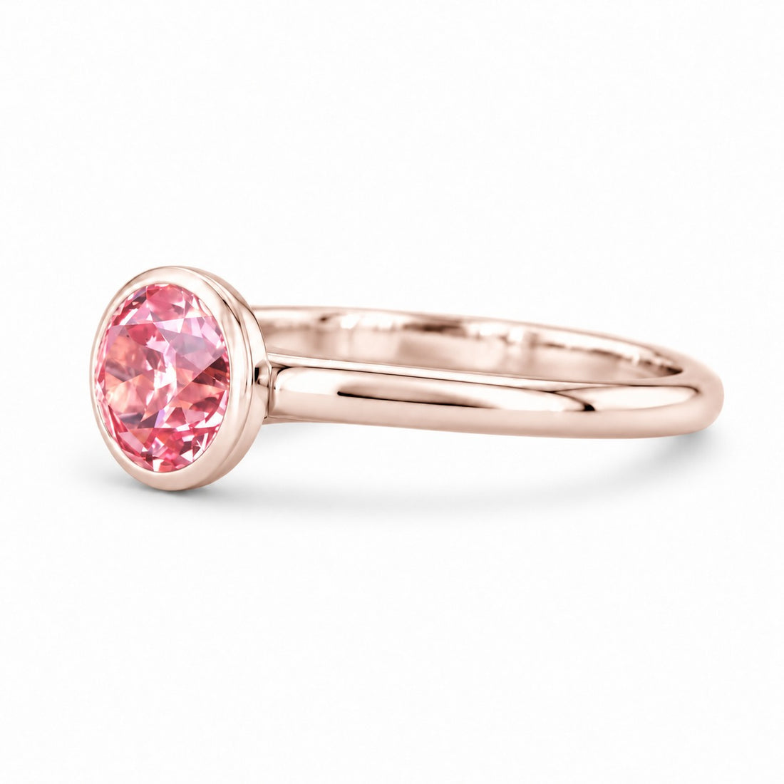 The Lune pink lab sapphire bezel solitaire ring in 14K rose gold, angled view