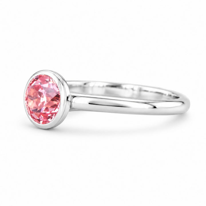 The Lune pink lab sapphire bezel solitaire ring in 14K white gold, angled view