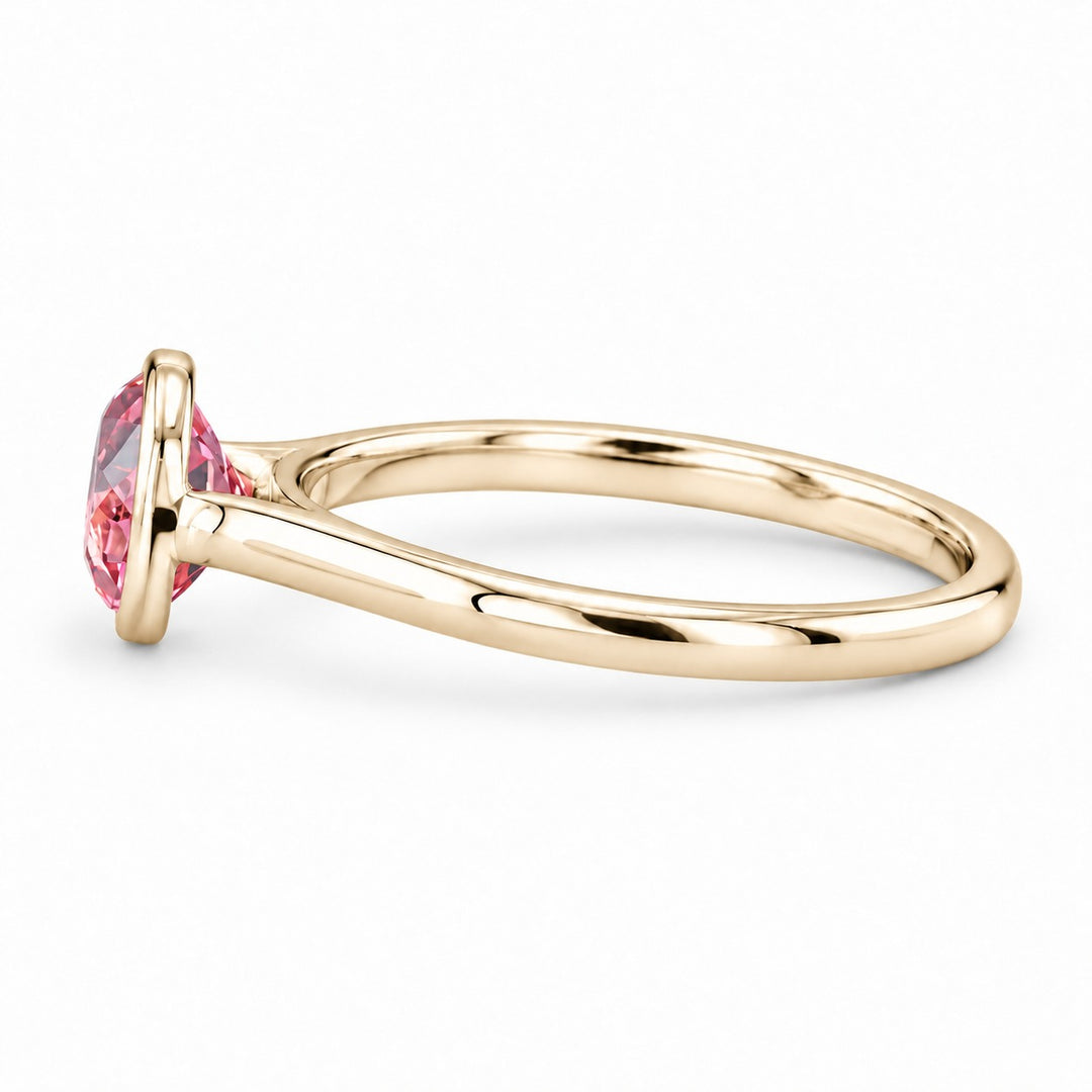 The Lune pink lab sapphire bezel solitaire ring in 14K yellow gold, side view