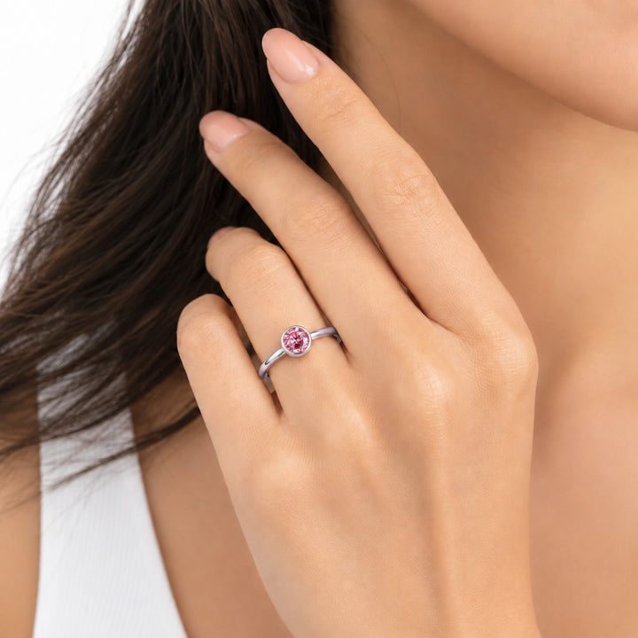 The Lune pink lab sapphire bezel solitaire ring in platinum, worn on hand