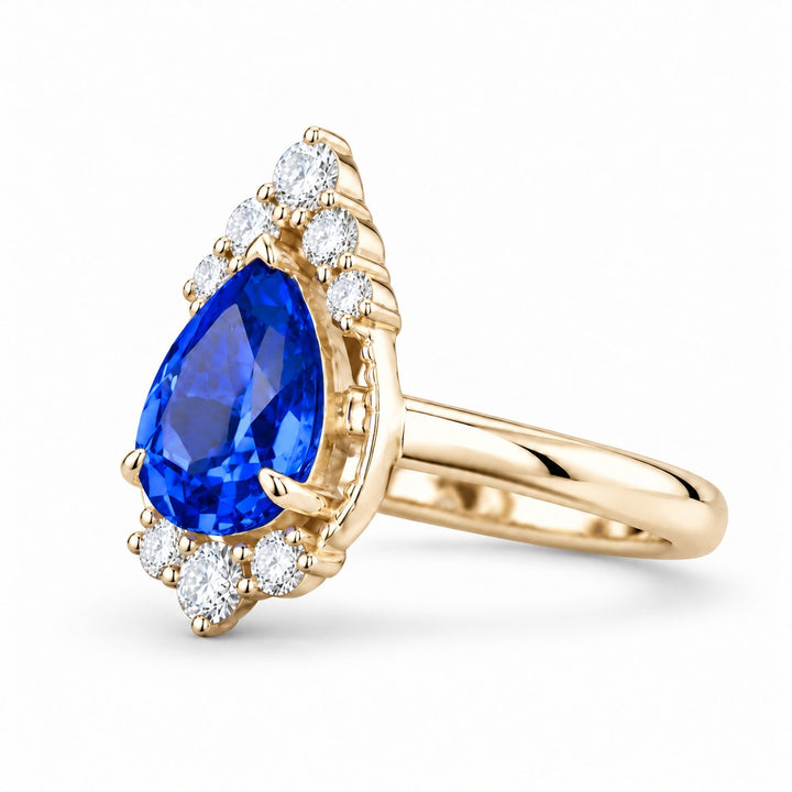 The Teardrop pear blue sapphire ring with diamond halo in 14K yellow gold, angled view
