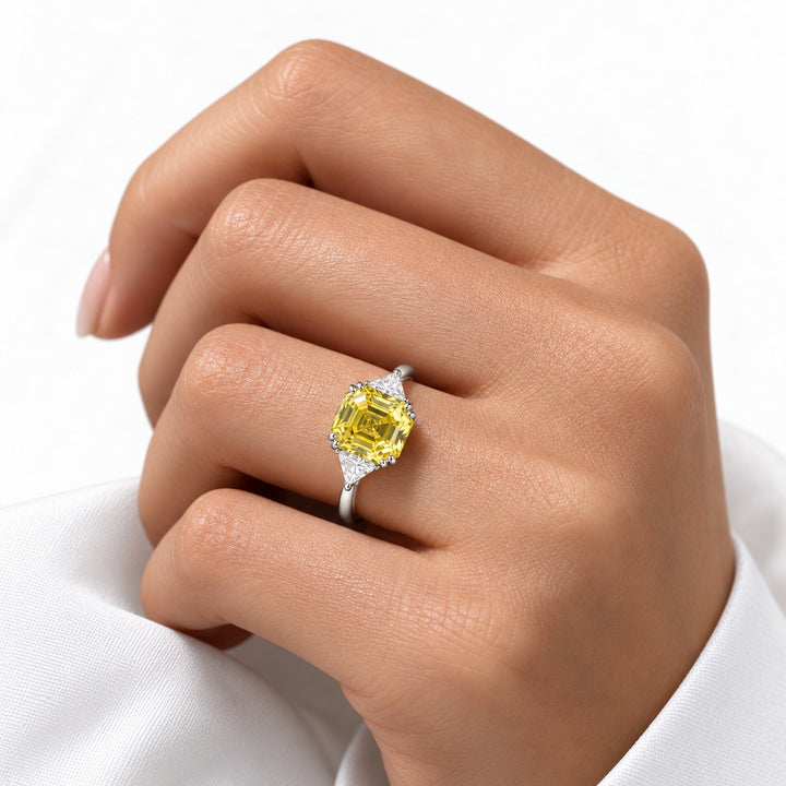 The Sundial asscher yellow lab sapphire three-stone ring in 14K white gold, worn on hand