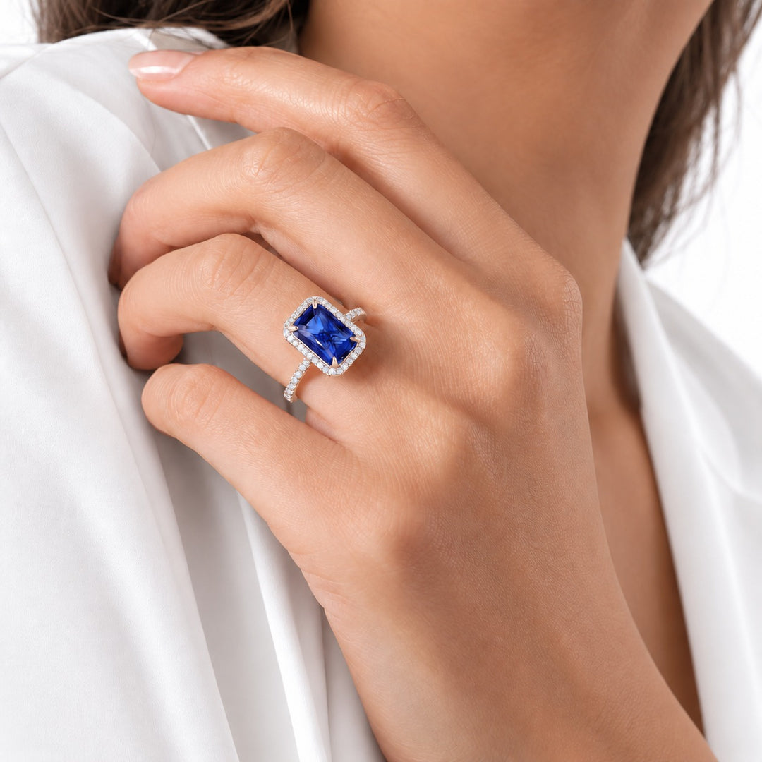 The Regalia emerald-cut lab sapphire halo ring in 14K rose gold, worn on hand