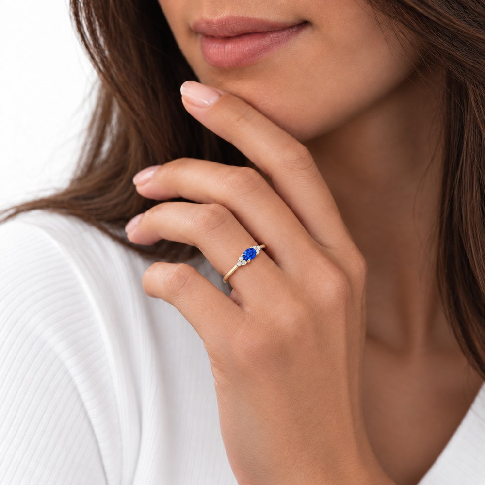 The Wren east-west oval blue sapphire ring in 14K yellow gold, worn on hand