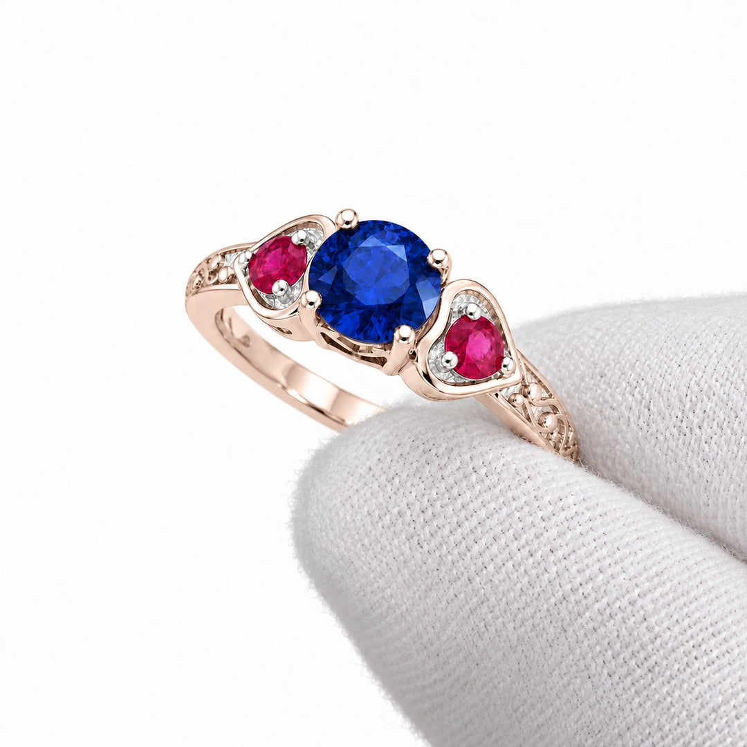 Sapphire and ruby three-stone ring with leaf band in 14K rose gold, angled view