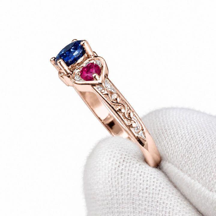 Sapphire and ruby three-stone ring with leaf band in 14K rose gold, detail view