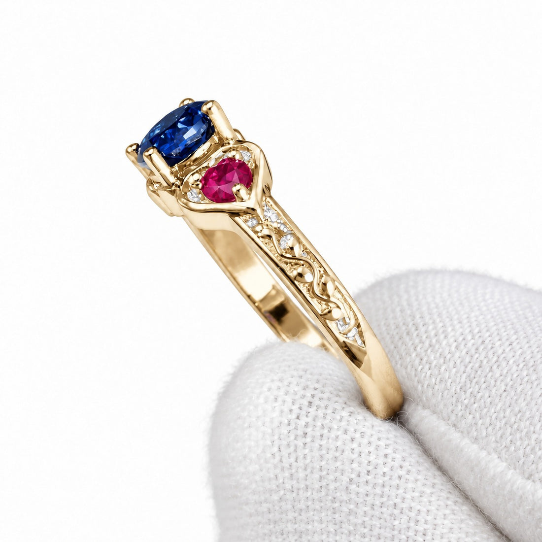 Sapphire and ruby three-stone ring with leaf band in 14K yellow gold, detail view
